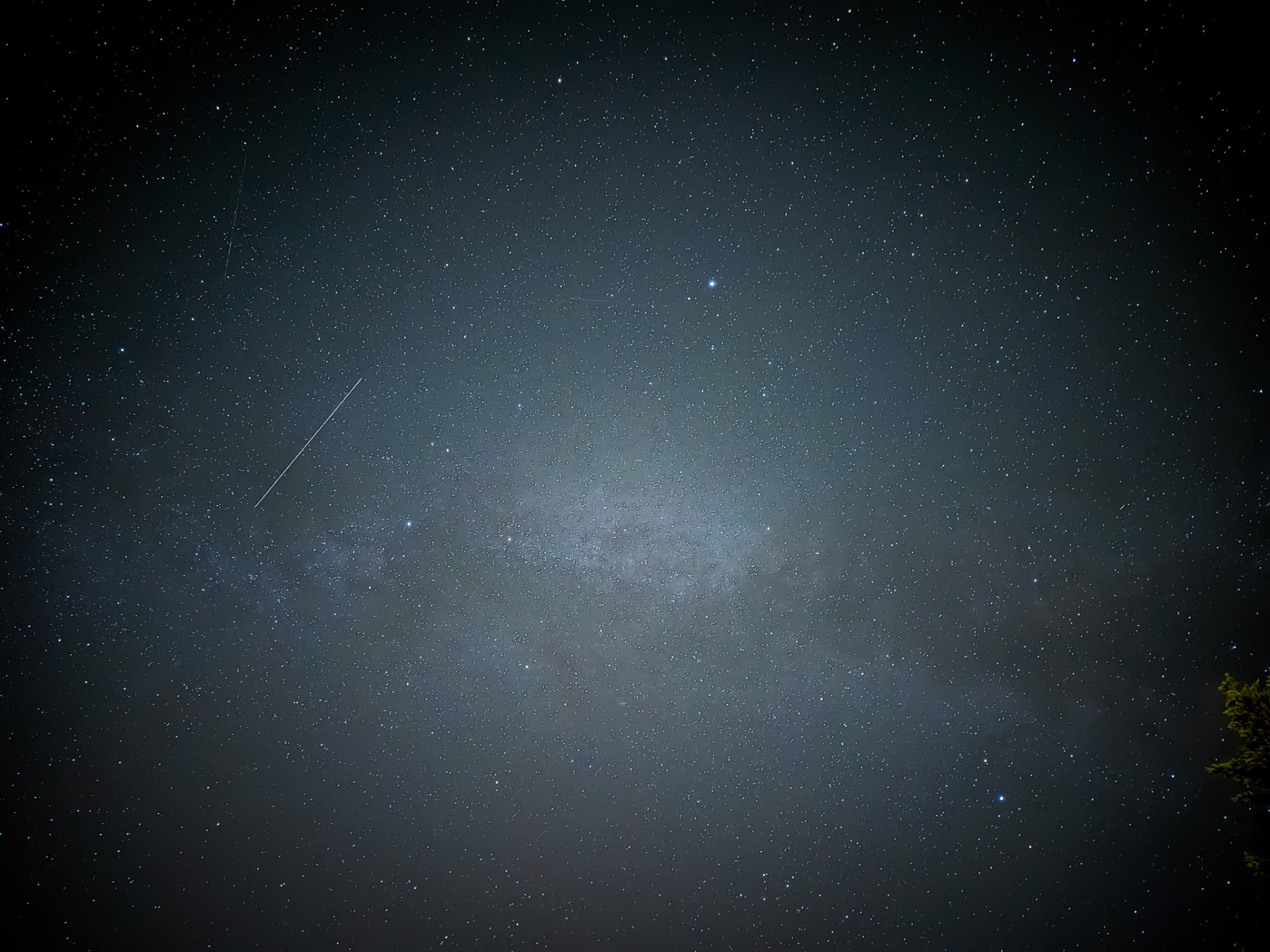 Dense galactic core with a faint meteor trail across a starry sky
